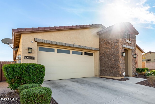 19889 W Montecito Ave, Litchfield Park, AZ 85340 - view of front facade featuring concrete driveway, stucco siding, a garage, and stone siding