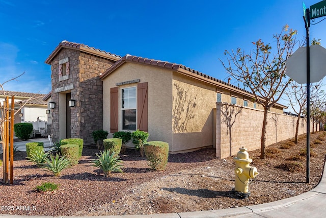 19889 W Montecito Ave, Litchfield Park, AZ 85340 - view of side of home featuring stucco siding and a tiled roof