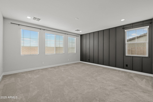 empty room featuring light colored carpet, baseboards, and recessed lighting