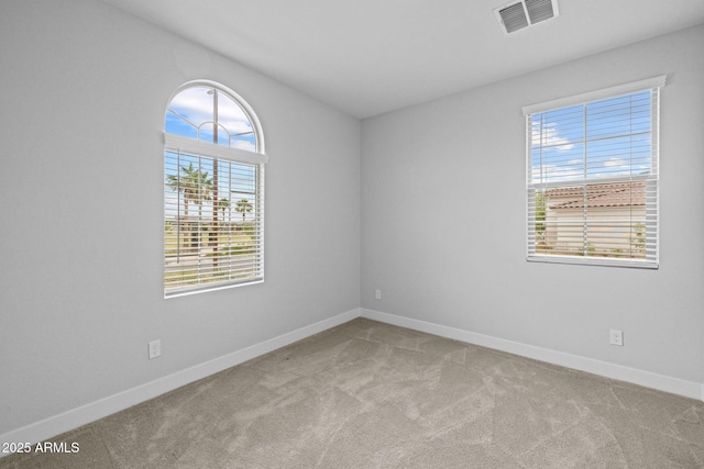 carpeted spare room featuring baseboards