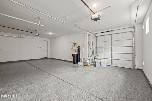 garage featuring a garage door opener and baseboards