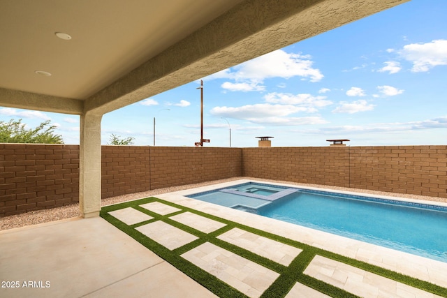 view of pool featuring a fenced backyard, a pool with connected hot tub, and a patio area