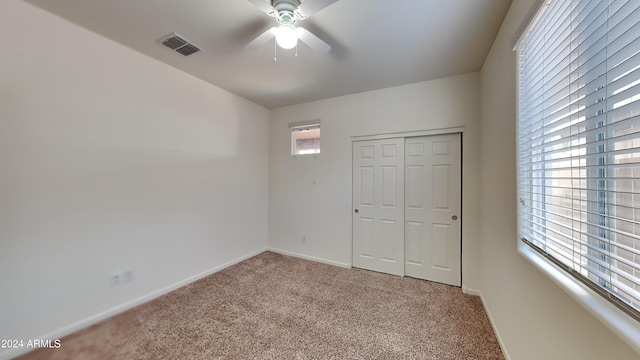 unfurnished bedroom with carpet flooring, ceiling fan, and a closet