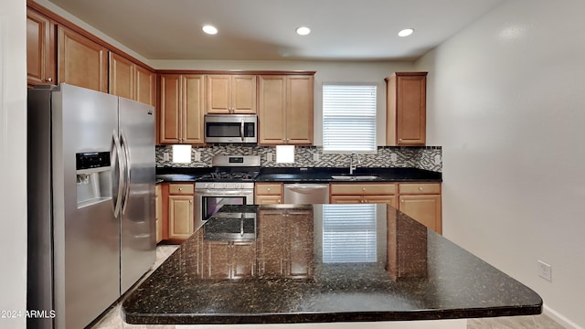 kitchen with decorative backsplash, sink, a kitchen island, and stainless steel appliances