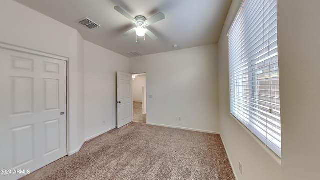 unfurnished bedroom featuring ceiling fan and light colored carpet