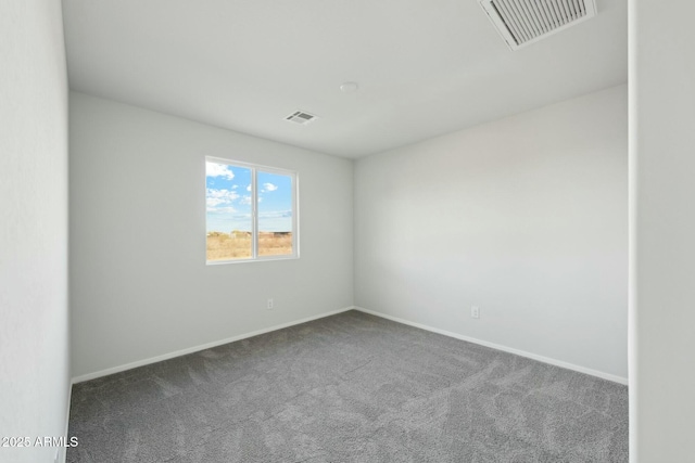 spare room with carpet flooring, visible vents, and baseboards