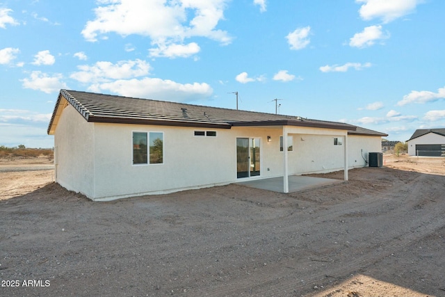 rear view of property with a patio area, cooling unit, and stucco siding