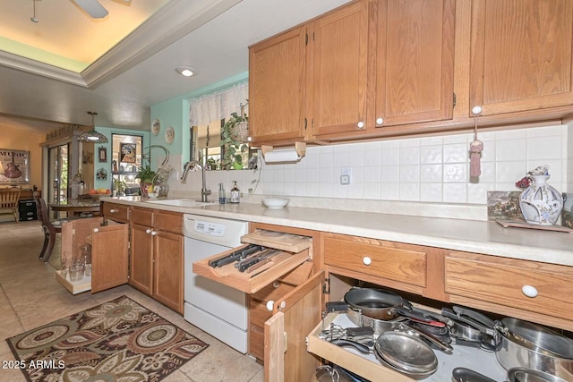 kitchen with light countertops, white dishwasher, backsplash, and a sink