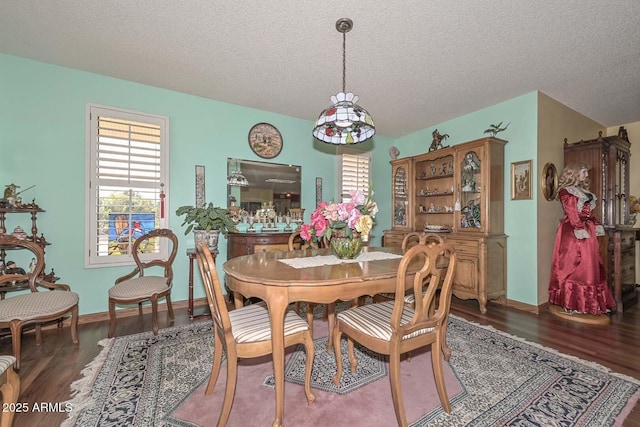 dining space featuring baseboards, a textured ceiling, and wood finished floors