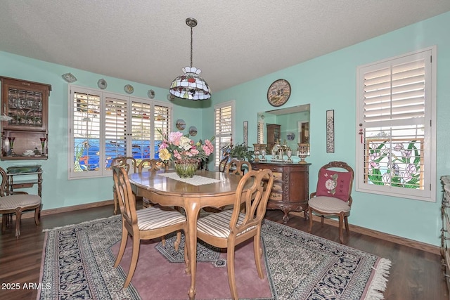 dining area featuring plenty of natural light, wood finished floors, and a textured ceiling