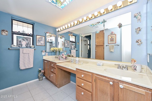 full bathroom featuring a sink, baseboards, double vanity, and tile patterned flooring