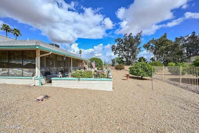 view of yard featuring fence and a sunroom