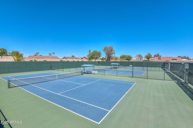 view of tennis court with community basketball court and fence