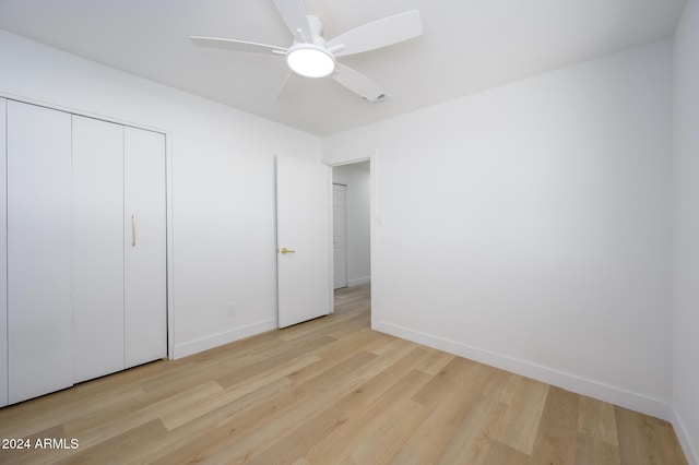 unfurnished bedroom featuring a closet, light hardwood / wood-style flooring, and ceiling fan