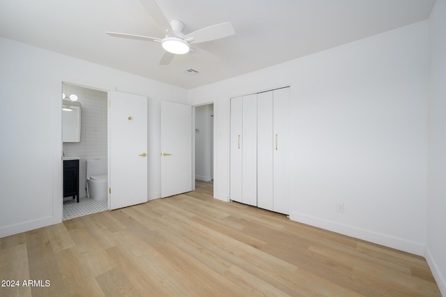 unfurnished bedroom featuring a closet, connected bathroom, ceiling fan, and light hardwood / wood-style flooring