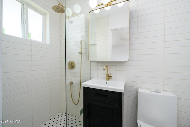 bathroom with toilet, vanity, and tiled shower