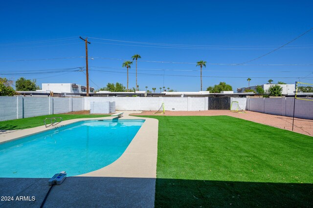 view of swimming pool with a yard