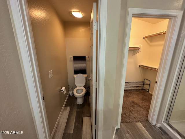 6920 S 46th Dr, Laveen, AZ 85339 - bathroom with wood finished floors, toilet, a spacious closet, and baseboards