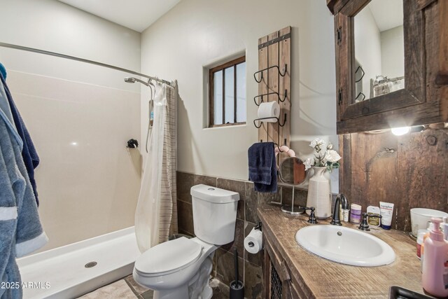 21131 E Excelsior Ave, Queen Creek, AZ 85142 - full bathroom featuring toilet, a stall shower, vanity, tile walls, and a wainscoted wall