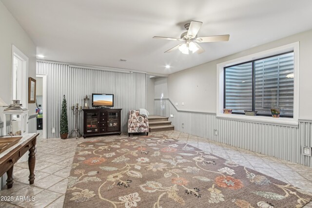 21131 E Excelsior Ave, Queen Creek, AZ 85142 - tiled living room featuring ceiling fan, stairway, and a wainscoted wall