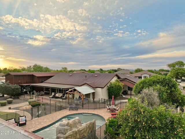 21131 E Excelsior Ave, Queen Creek, AZ 85142 - pool at dusk featuring a fenced backyard, a patio, and a hot tub