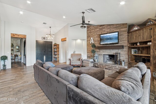 21131 E Excelsior Ave, Queen Creek, AZ 85142 - living area featuring light wood finished floors, a fireplace, a ceiling fan, high vaulted ceiling, and a chandelier