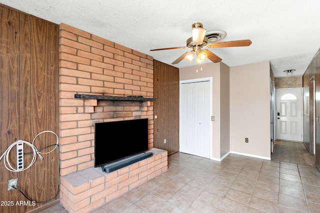 841 W Spray St, Superior, AZ 85173 - unfurnished living room featuring a ceiling fan, a fireplace, tile patterned flooring, a textured ceiling, and baseboards