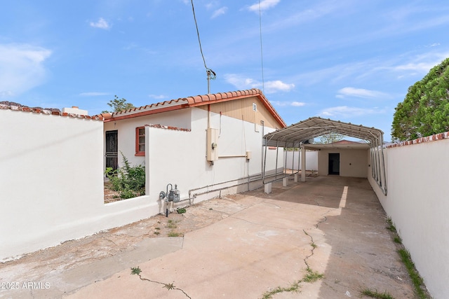 841 W Spray St, Superior, AZ 85173 - view of property exterior featuring a detached carport, concrete driveway, a tiled roof, and stucco siding