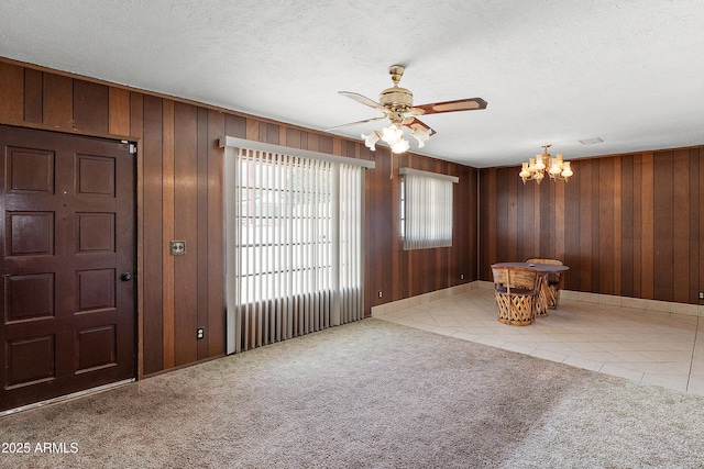 841 W Spray St, Superior, AZ 85173 - unfurnished living room with a chandelier, ceiling fan, tile patterned flooring, wood walls, and carpet floors