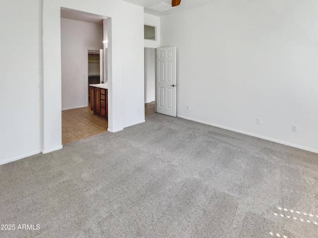 18207 W Marshall Ln, Surprise, AZ 85388 - unfurnished bedroom featuring carpet floors, baseboards, tile patterned flooring, and ensuite bath