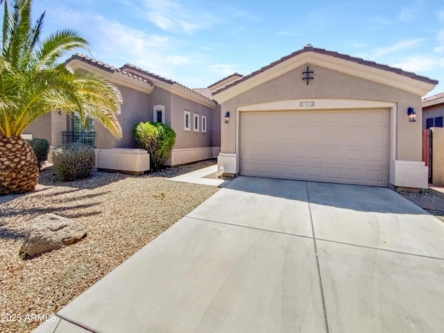 18207 W Marshall Ln, Surprise, AZ 85388 - view of front of house featuring a tiled roof, a garage, driveway, and stucco siding