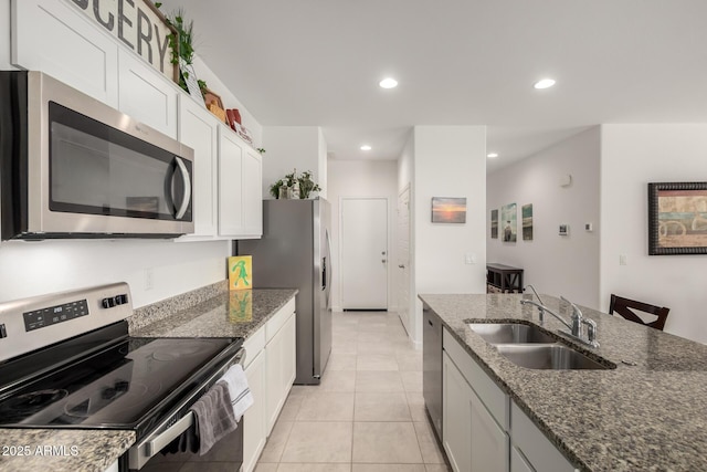 kitchen with appliances with stainless steel finishes, sink, white cabinets, and dark stone counters