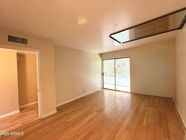 1702 W Tuckey Ln Unit 209, Phoenix, AZ 85015 - unfurnished room with light wood-style floors and baseboards