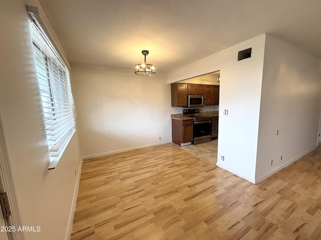 1702 W Tuckey Ln Unit 209, Phoenix, AZ 85015 - kitchen featuring appliances with stainless steel finishes, light wood-type flooring, a chandelier, baseboards, and pendant lighting