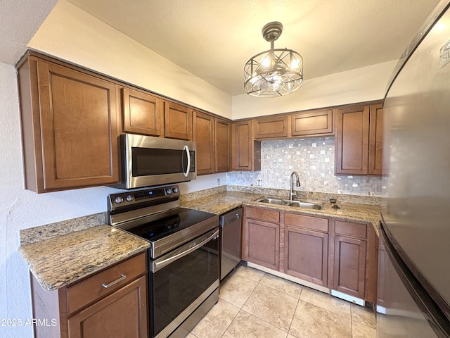 1702 W Tuckey Ln Unit 209, Phoenix, AZ 85015 - kitchen with stainless steel appliances, a sink, decorative backsplash, light stone countertops, and light tile patterned floors