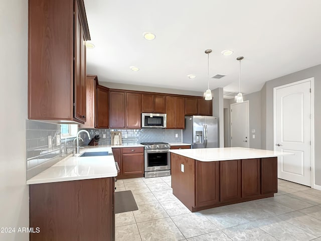 kitchen featuring sink, a center island, tasteful backsplash, pendant lighting, and appliances with stainless steel finishes