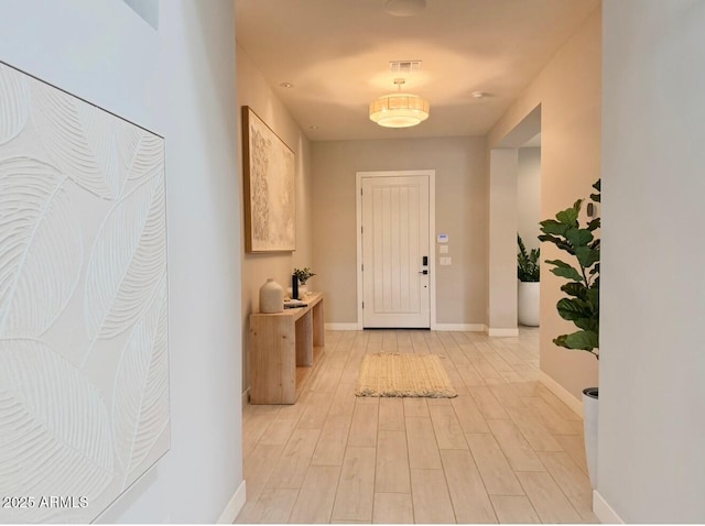 interior space featuring light wood-type flooring, baseboards, and visible vents
