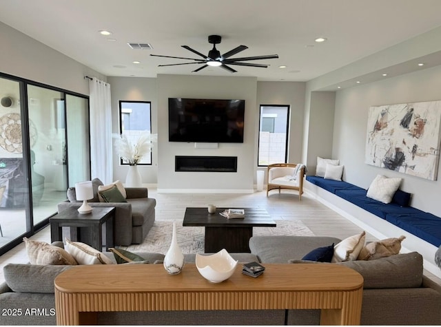 living area featuring visible vents, a fireplace, baseboards, ceiling fan, and recessed lighting