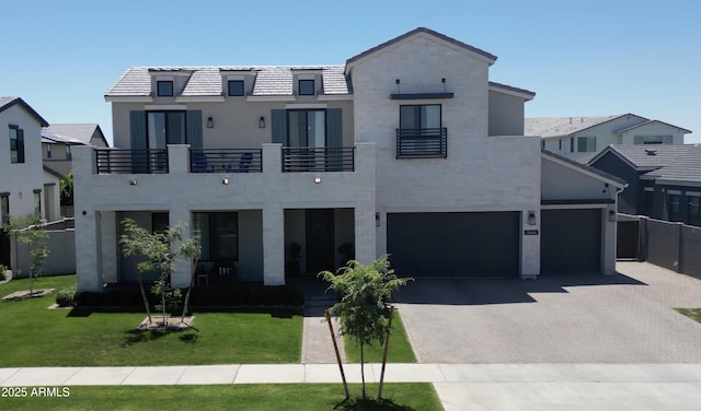view of front of house featuring a front yard, decorative driveway, and a balcony