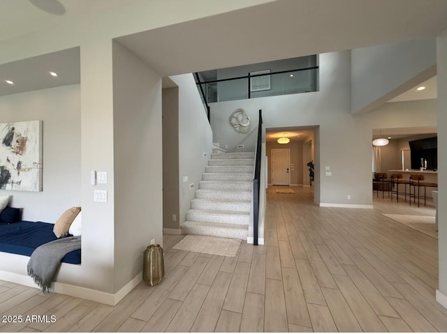 stairs featuring recessed lighting, baseboards, and wood finished floors