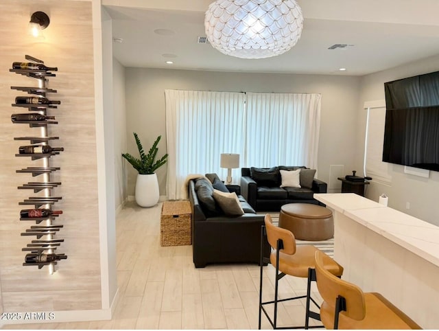 living area with recessed lighting, baseboards, visible vents, and light wood-style floors