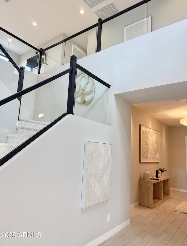 interior space with baseboards, recessed lighting, wood finished floors, and visible vents