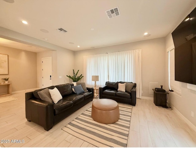 living room with recessed lighting, baseboards, visible vents, and light wood finished floors