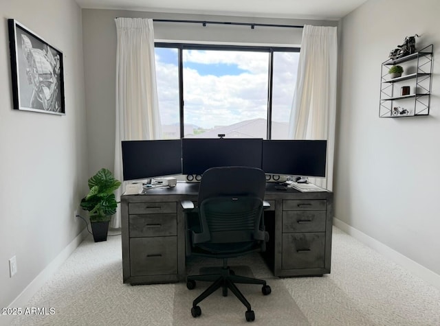 carpeted home office featuring baseboards