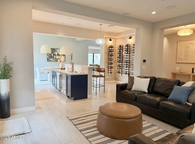 living area featuring baseboards, recessed lighting, and light wood-style floors