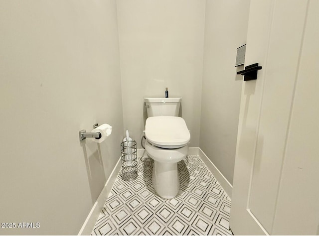 bathroom featuring baseboards and toilet