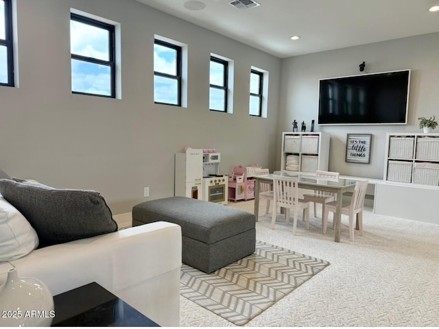 living room with recessed lighting, light colored carpet, and visible vents