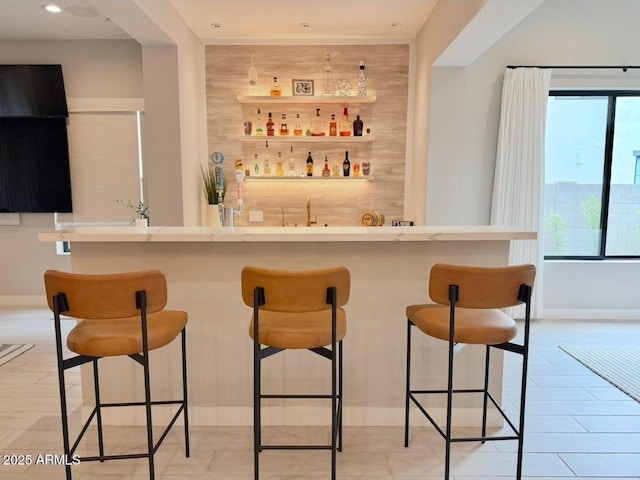 bar with baseboards, recessed lighting, and wet bar