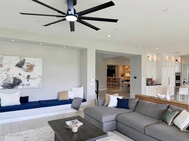 living area featuring recessed lighting, a ceiling fan, baseboards, and light wood-style flooring