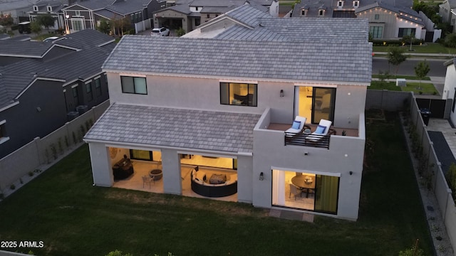 back of house featuring a residential view, stucco siding, a yard, and a fenced backyard